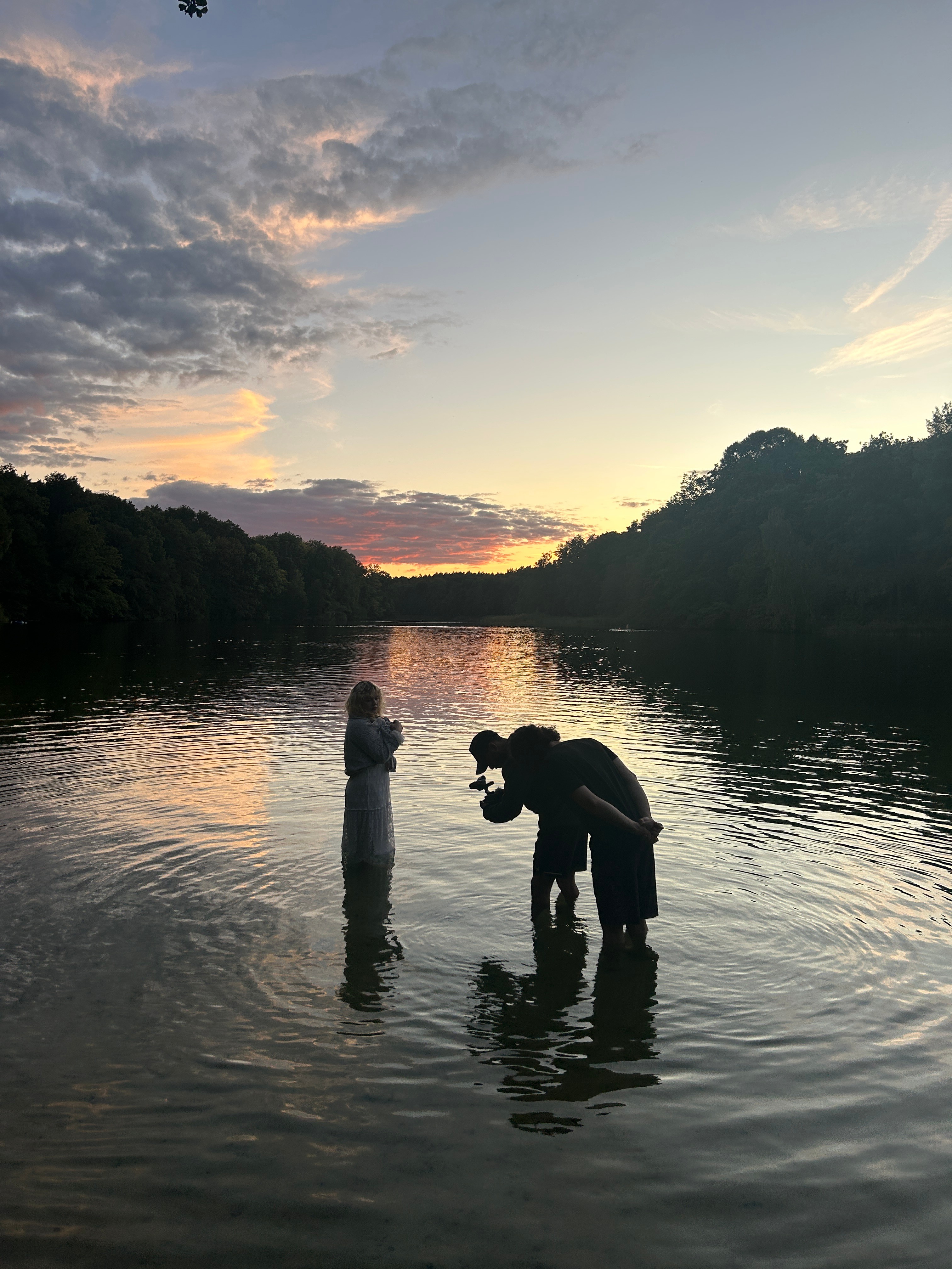 camera operator filming one person in a lake
