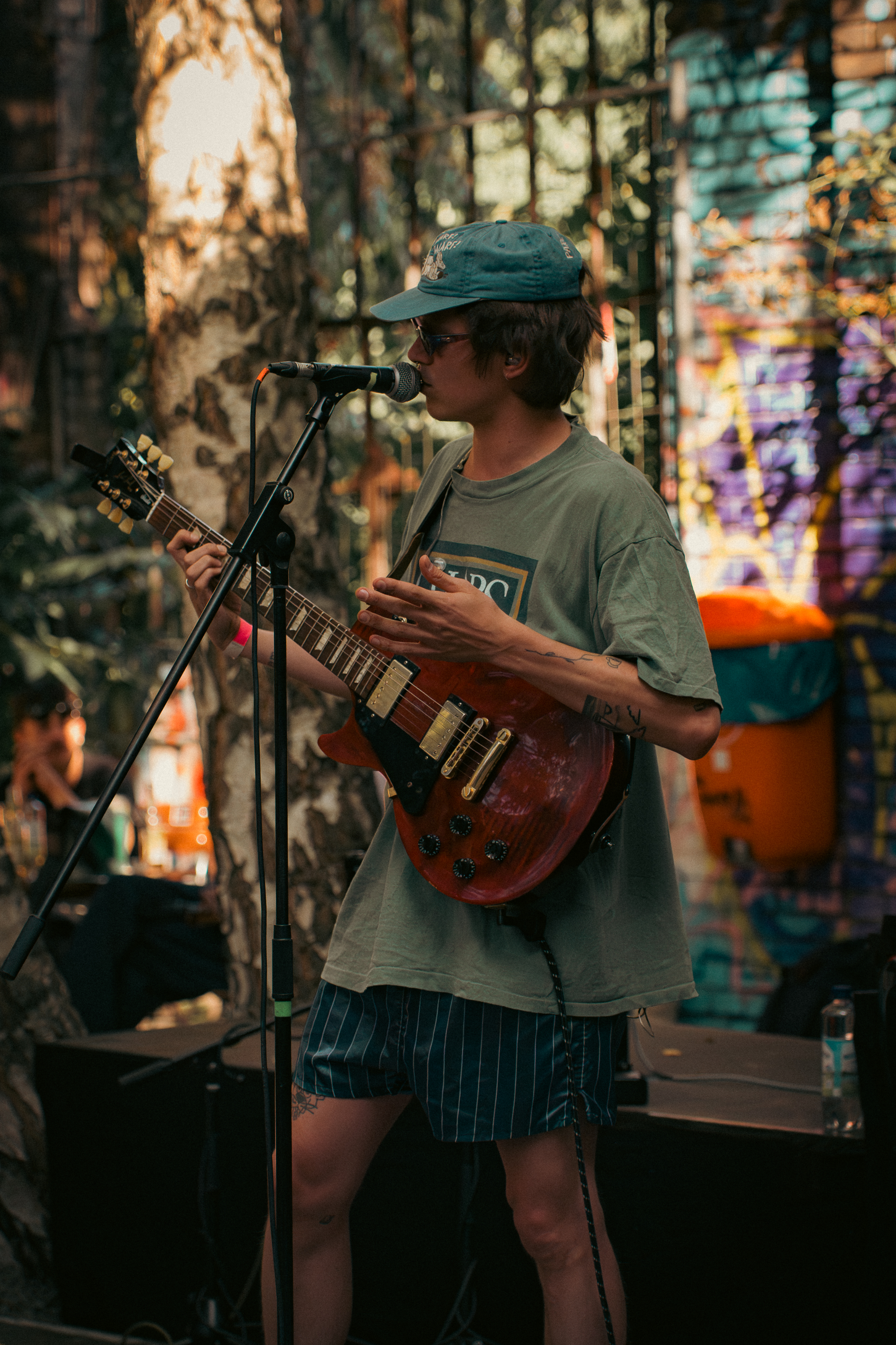 person playing guitar and singing on stage